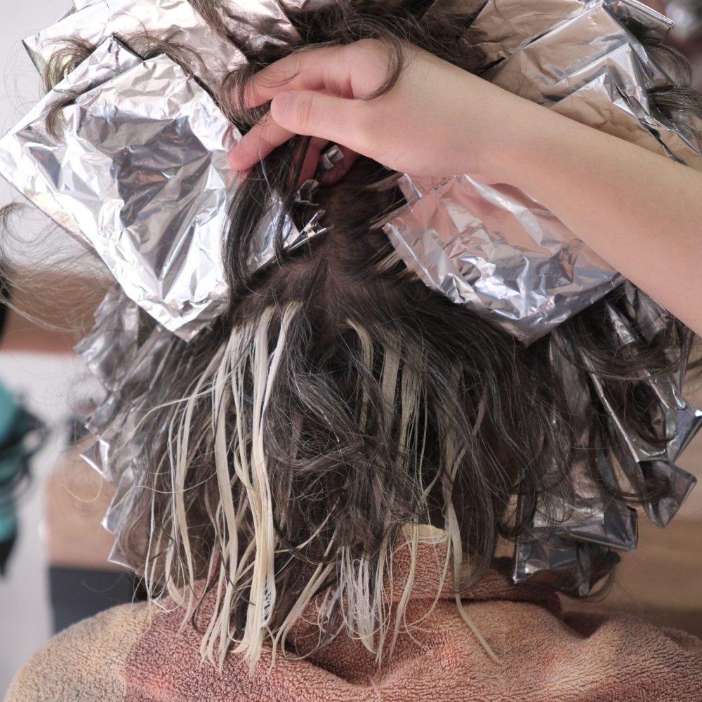 A detailed shot of hair coloring process using foils at a salon in İzmir, Türkiye.